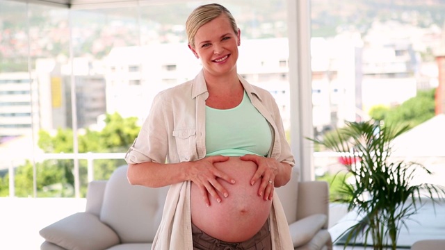 孕妇在客厅里展示自己的肚子视频素材