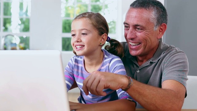 爷爷和女儿在厨房用笔记本电脑视频素材
