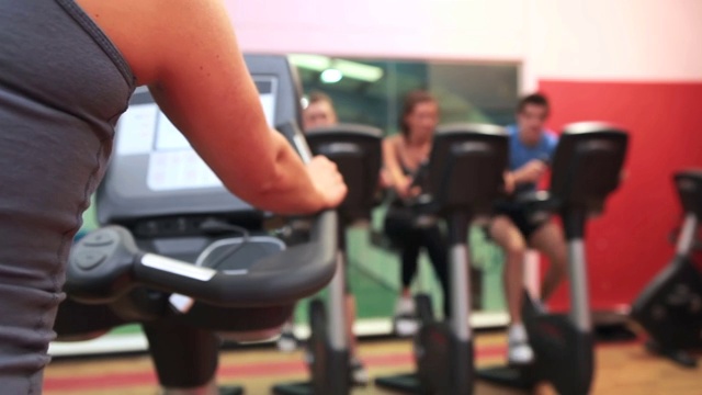 人们在健身房上动感单车课特写视频下载