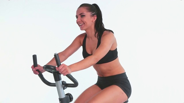 女人在骑动感单车锻炼特写视频下载