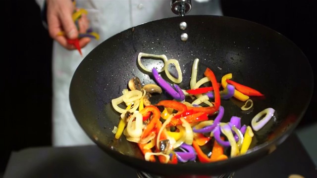 厨师在翻炒锅里的蔬菜特写视频素材