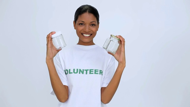 志愿者女生拿着两个罐子展示给镜头特写视频素材