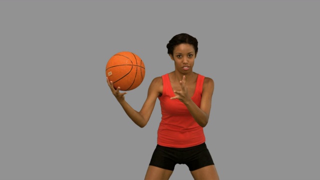 女人在灰色背景下打篮球特写视频下载