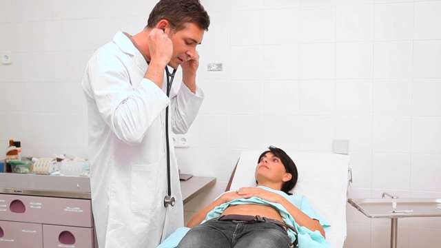 医生在检查室用听诊器检查腹部特写视频素材