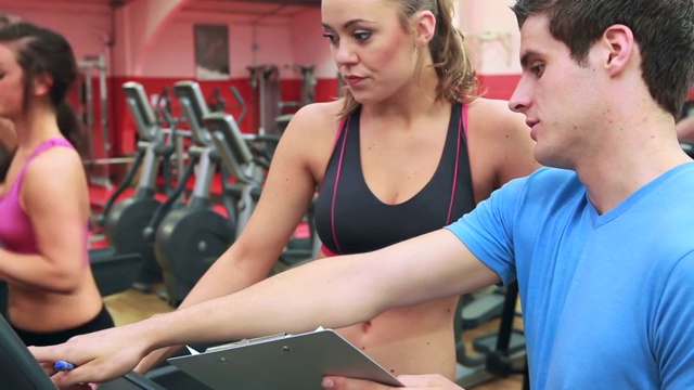 女人在健身房和她的教练聊天视频下载