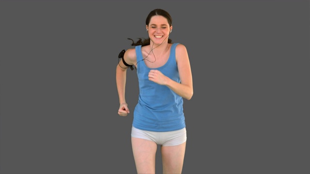 女人穿着运动服在灰色背景下跑步特写视频下载