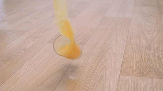 一杯橙汁超级慢镜头掉在地板上视频素材