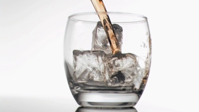 威士忌倒进装满冰块的杯中特写视频素材