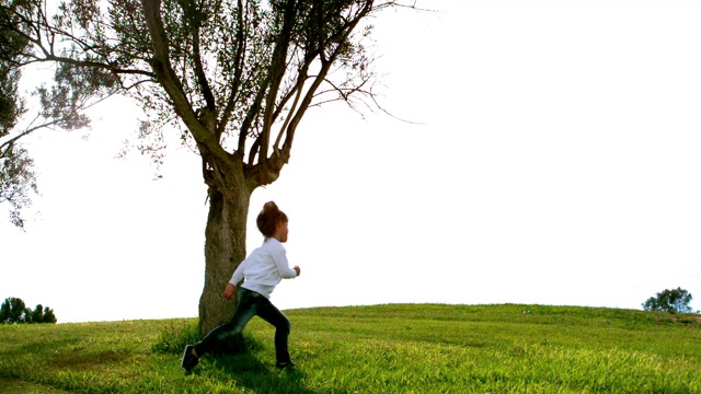 小女孩绕着树跑的慢镜头视频素材