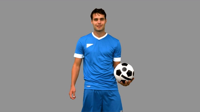 一个足球运动员在灰色背景下练习足球特写视频素材
