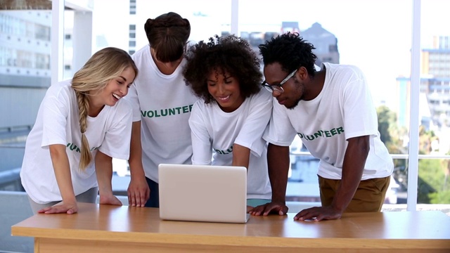 一群志愿者拿着电脑讨论特写视频素材