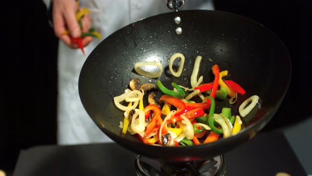 厨师在翻炒锅里的蔬菜特写视频素材