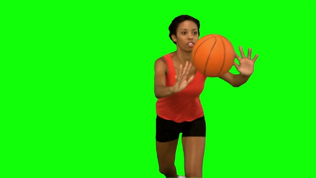 女人在绿色背景下打篮球特写视频素材