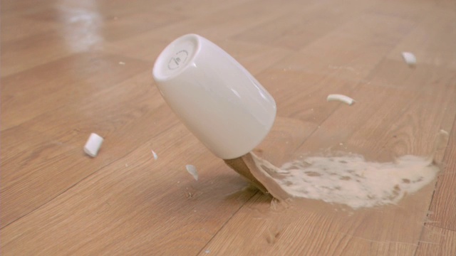 一杯超慢镜头的白咖啡掉在地板上视频素材