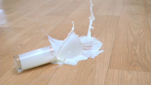 一杯牛奶摔到地板上特写视频素材