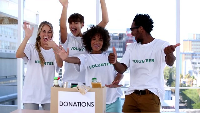 一群志愿者看着捐款箱里的食物欢呼特写视频素材