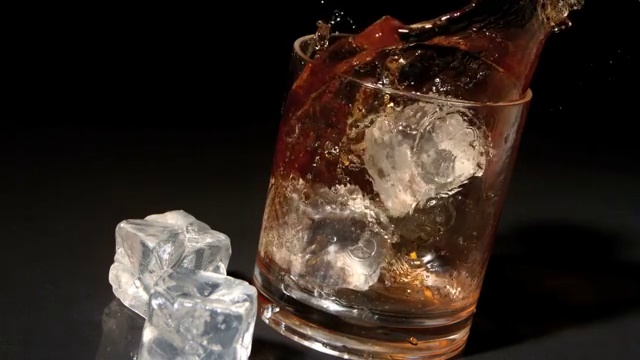 三个冰块掉入威士忌杯中特写视频素材