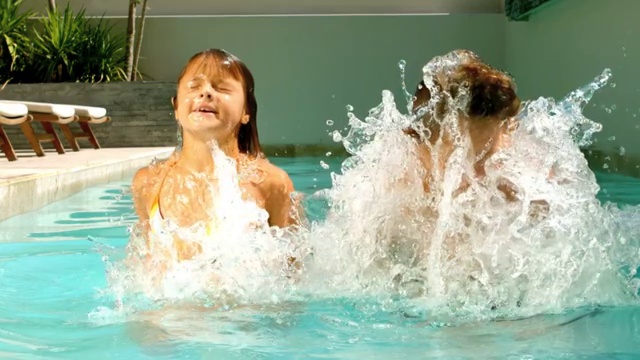 兄弟姐妹在一个阳光明媚的日子里以每秒500帧的慢镜头在游泳池里嬉戏视频下载