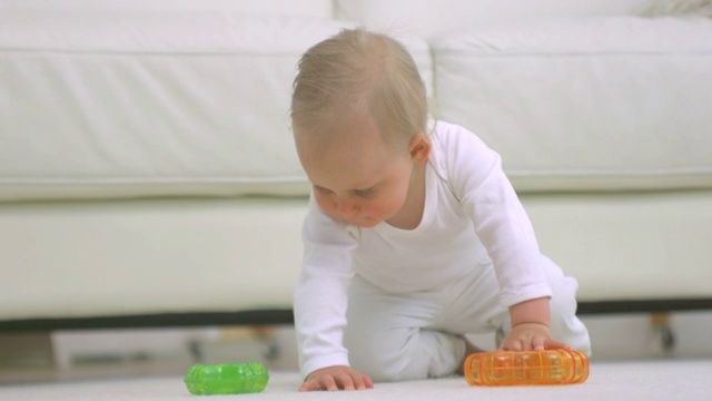 婴儿在地板上玩玩具爬行特写视频下载