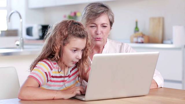 孩子和奶奶在厨房用笔记本电脑视频素材