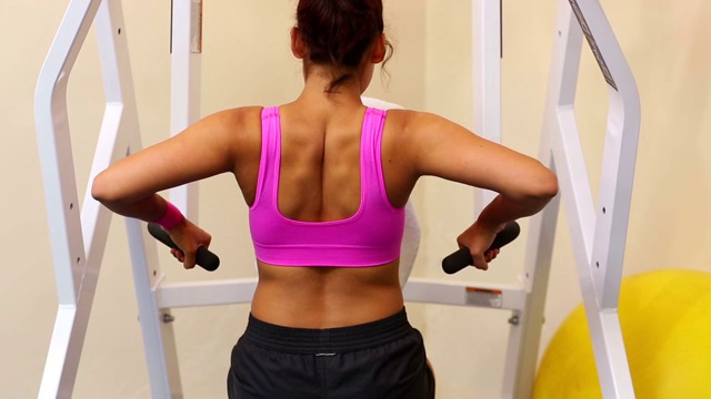 结实的女人训练她的手臂肌肉使用锻炼设备视频下载