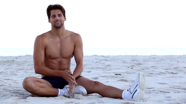 赤裸上身的男人在海滩上伸懒腰视频下载