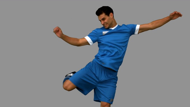 一个足球运动员在灰色背景下练习足球特写视频下载