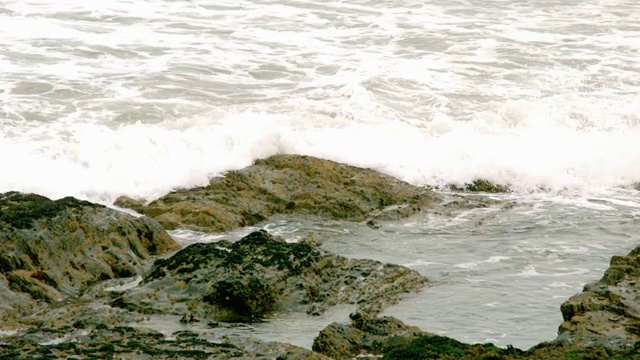 海浪在岩石上缓慢地翻滚视频下载
