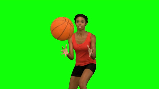 女人在绿色背景下打篮球特写视频素材