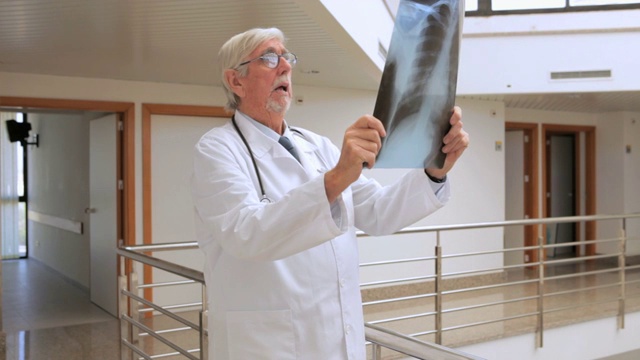 一名男医生在走廊里看x光片的视频视频下载