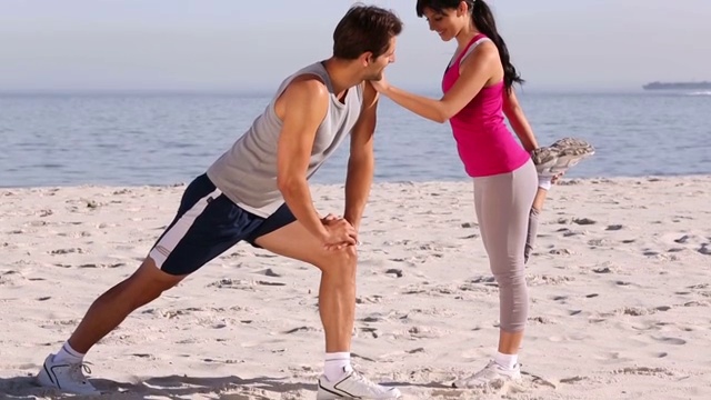 一对情侣在海滩上锻炼特写视频下载