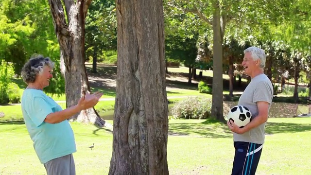 一对快乐的成熟夫妇在乡下玩足球视频素材