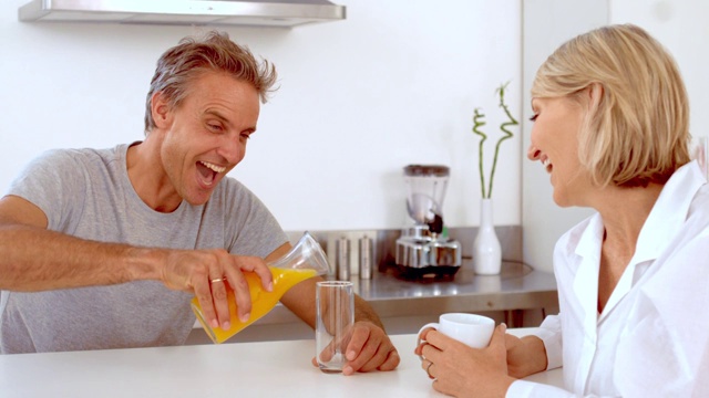 在慢镜头中，一个快乐的男人正在倒橙汁视频下载