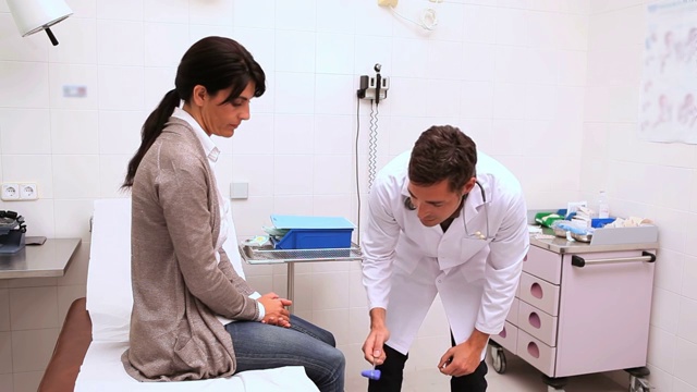 医生在检查室检查病人膝跳反应特写视频素材