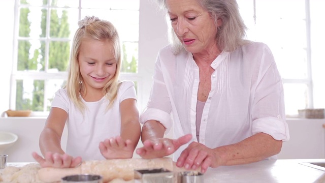 奶奶和孙女在厨房用擀面杖特写视频下载
