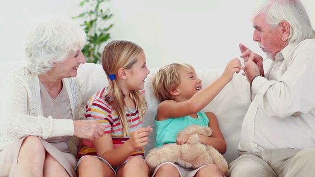 孩子们和爷爷奶奶在沙发上玩耍视频下载