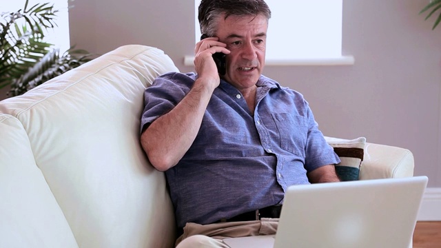 男人坐在沙发上打电话特写视频素材