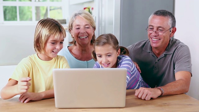 祖父母和孩子们在厨房看电脑特写视频素材
