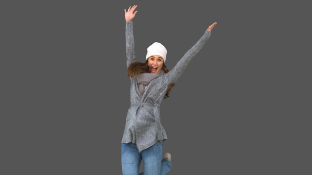 女人穿着冬装在灰色背景下欢呼特写视频下载
