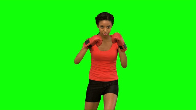 女人在绿色背景下打拳击特写视频下载