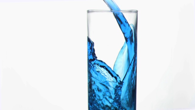 将蓝色液体倒入玻璃杯中特写视频下载