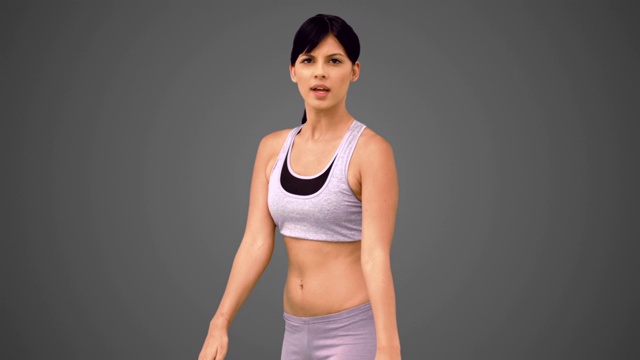 女人穿着运动服在灰色背景下锻炼特写视频下载