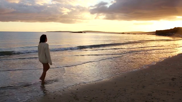 女人在日落时在海滩散步特写视频下载