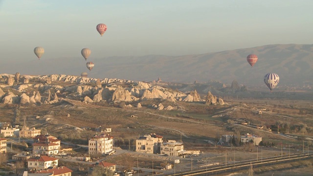 气球飞过土耳其卡帕多西亚的岩石山谷视频素材