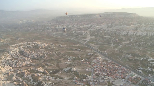 气球飞过土耳其卡帕多西亚的岩石山谷视频素材