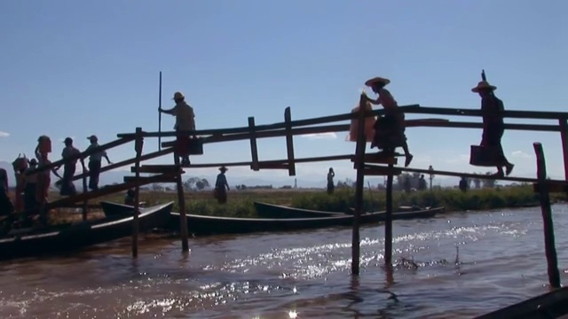 人们走在缅甸茵莱湖的桥上视频素材