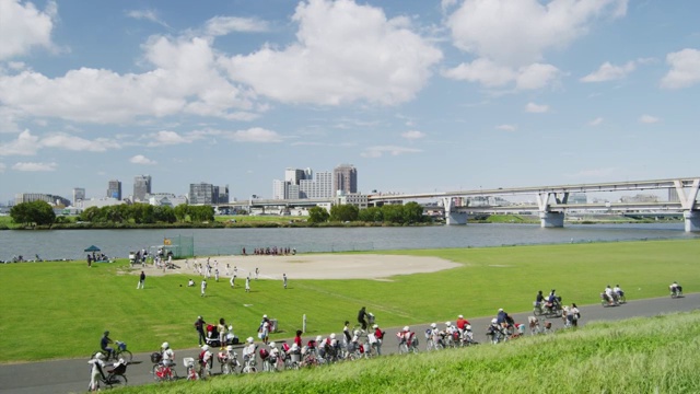 Kids playing baseball along Arakawa River in Tokyo, Japan视频素材
