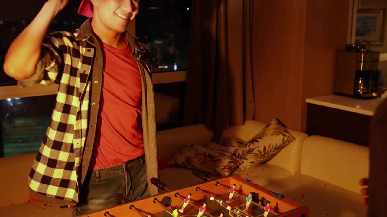 快乐的年轻人在客厅玩桌上足球视频下载