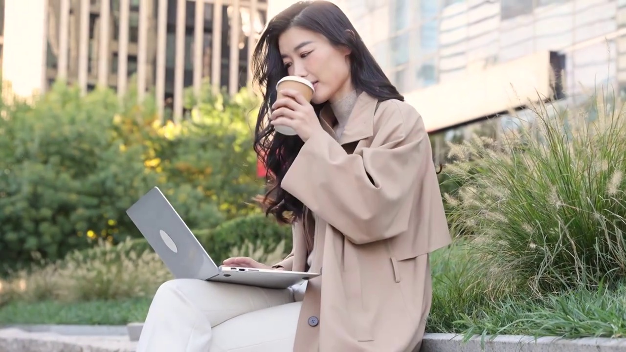 高知女商人在户外办公园区喝咖啡、使用笔记本电脑工作视频下载