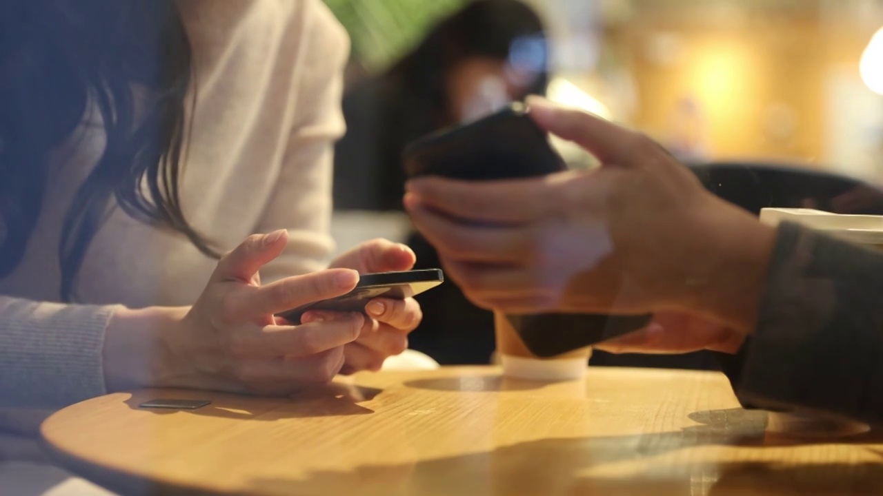高知商务女士们在咖啡店里使用手机手部特写视频下载